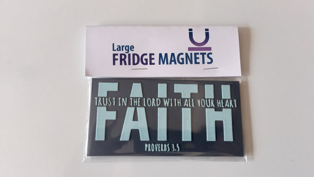 A packaged set of two fridge magnets on a plain light background. The top card reads 'Large FRIDGE MAGNETS' with a purple logo, and the magnet set below includes a dark magnet reading 'TRUST IN THE LORD WITH ALL YOUR HEART FAITH PROVERBS 3:5' in white and pale blue lettering.