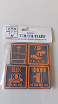 Four rectangular magnetic truth tiles in a clear plastic sleeve with a white backing card. The tiles are dark gray with orange borders and orange text/graphics, featuring biblical and motivational phrases like 'ASK', 'KNOCK', 'SEEK', and 'THE DOOR WILL OPEN' along with 'Matthew 7:7'.